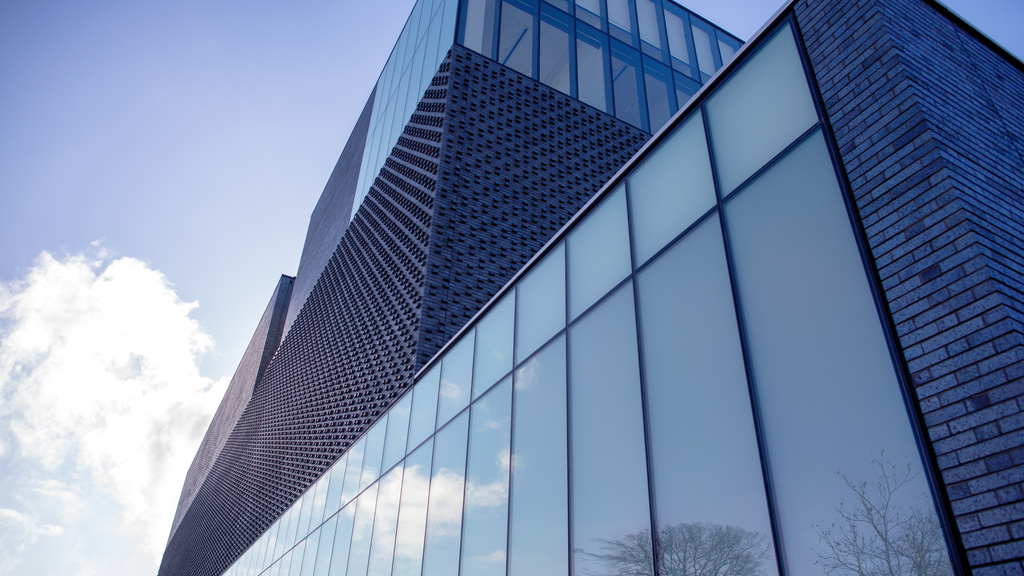 east front of museum with sky reflected in the glass