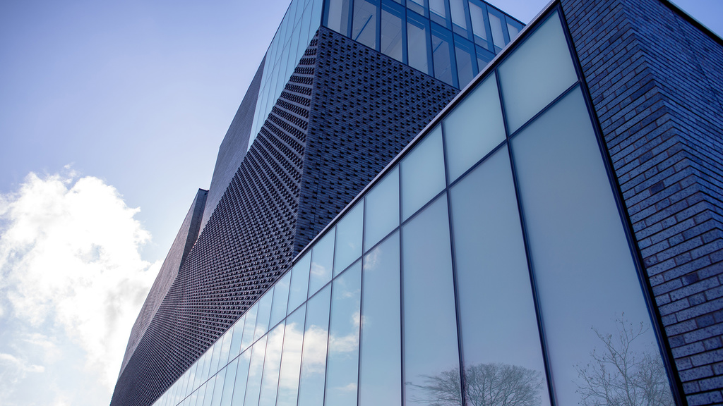 east front of museum with sky reflected in the glass